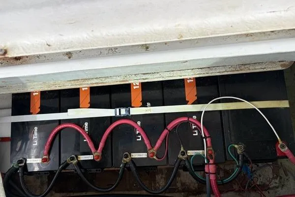 Slide: The Image of Battery compartment of a 1998 Leopard Catamaran with connected lithium batteries and wiring. - 46