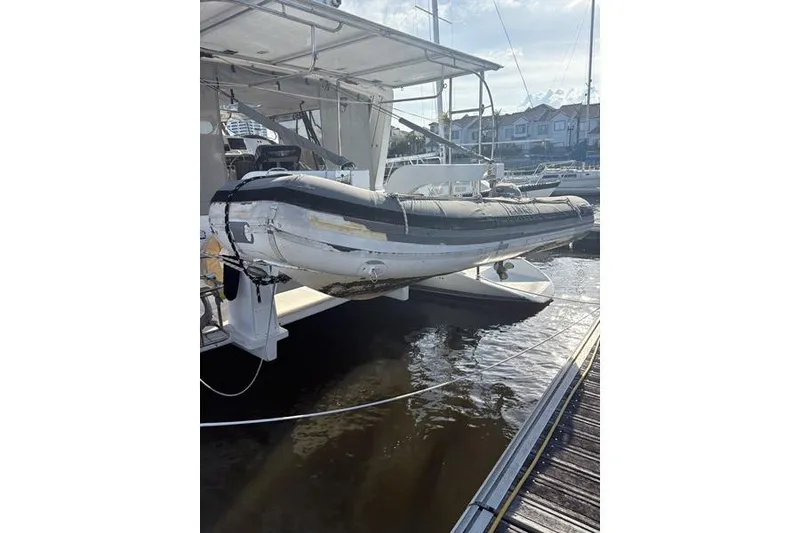 Slide: The Image of 1998 Leopard Catamaran with inflatable dinghy docked at marina. - 51