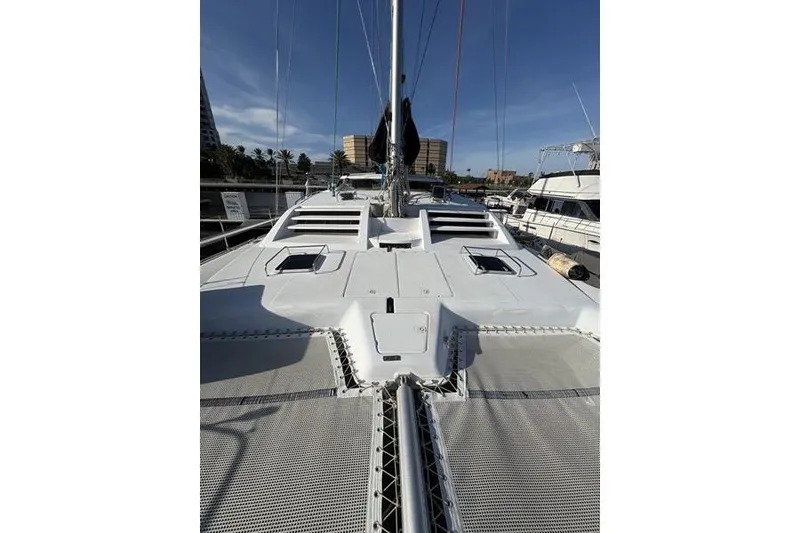 Slide: The Image of 1998 Leopard Catamaran deck view with netting, docked under clear blue sky. - 53