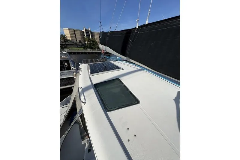 Slide: The Image of 1998 Leopard Catamaran deck with solar panels and sails, docked in marina. - 55