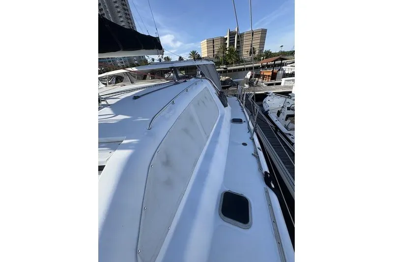 Slide: The Image of 1998 Leopard Catamaran docked at marina, showcasing sleek design and spacious deck. - 56