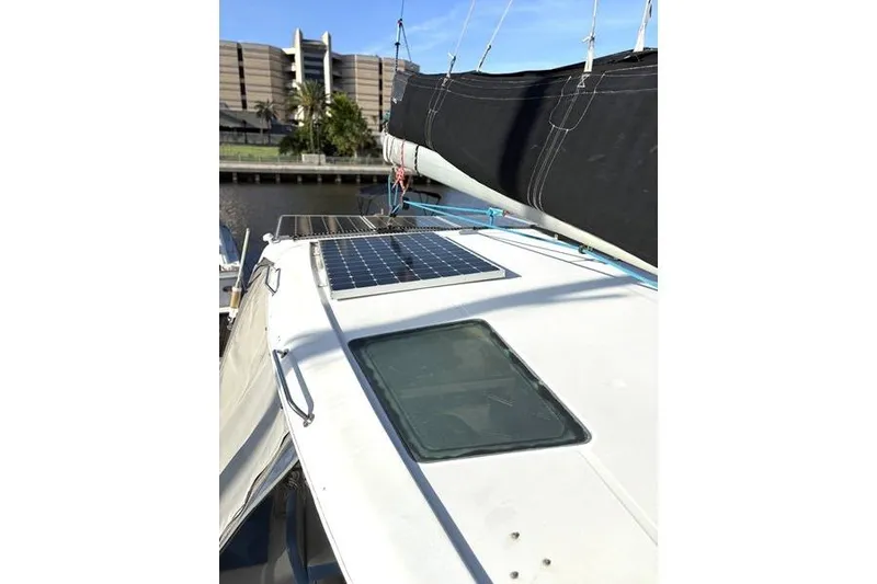 Slide: The Image of 1998 Leopard Catamaran with solar panel on deck, docked near modern building. - 57