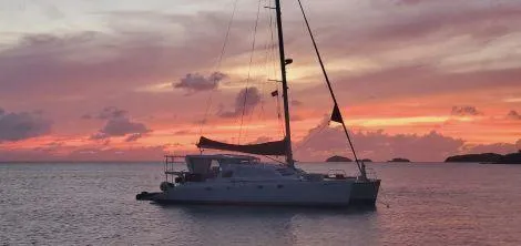 Slide: The Image of Leopard Catamaran 1998 sailing at sunset with vibrant sky and calm sea. - 6