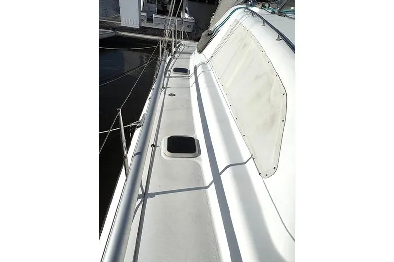 Slide: The Image of 1998 Leopard Catamaran deck view with railing and hatches, docked at marina. - 61
