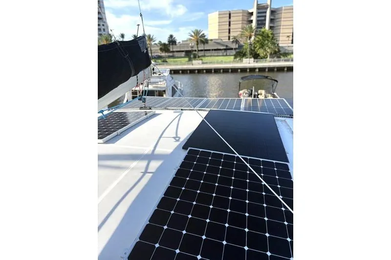 Slide: The Image of 1998 Leopard Catamaran with solar panels docked near waterfront buildings. - 62