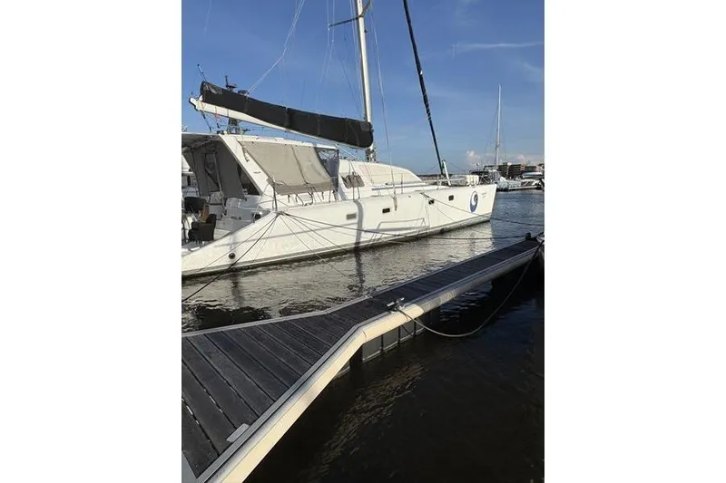 Slide: The Image of 1998 Leopard Catamaran docked at marina under clear blue sky. - 66