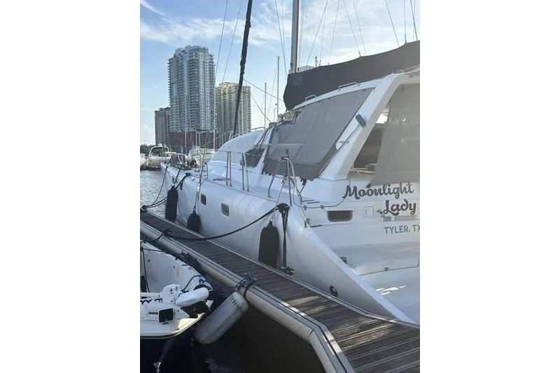 Slide: The Image of 1998 Leopard Catamaran docked at marina with city skyline in background. - 67