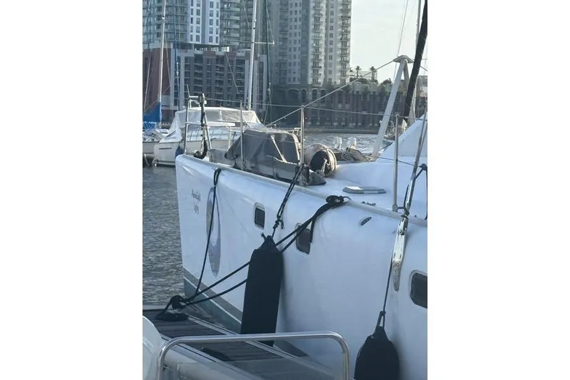 Slide: The Image of 1998 Leopard Catamaran docked in marina with cityscape background. - 68
