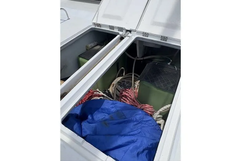 Slide: The Image of Open storage compartment on 1998 Leopard Catamaran with ropes and blue tarp. - 71