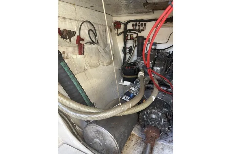 Slide: The Image of Engine room of a 1998 Leopard Catamaran with visible hoses and mechanical components. - 77
