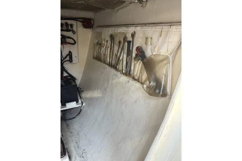 Slide: The Image of Tool storage area inside a 1998 Leopard Catamaran, featuring organized wrenches and equipment. - 87