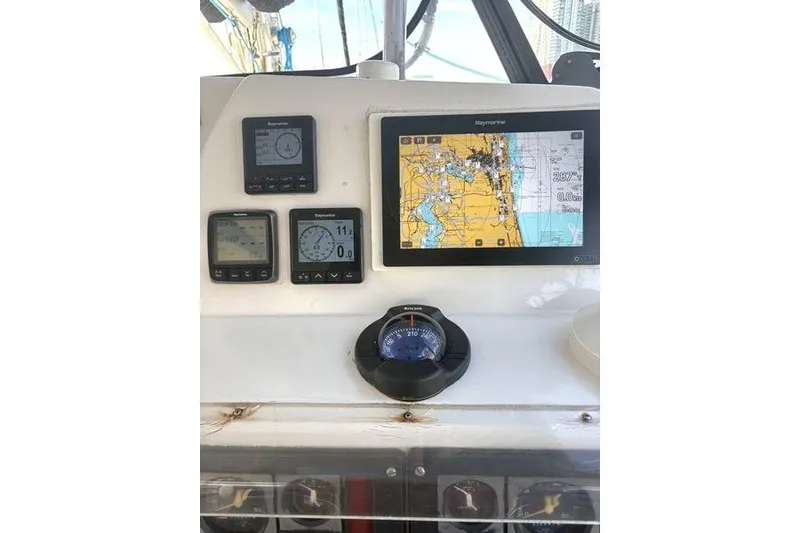 Slide: The Image of Navigation instruments on a 1998 Leopard Catamaran, featuring a Raymarine chartplotter and compass. - 91