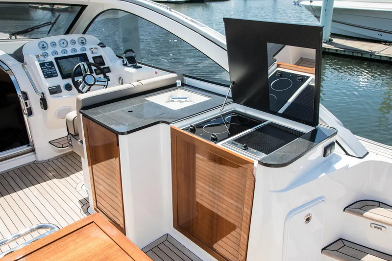 Slide: The Image of Keizer 42 yacht 2023 model, featuring a sleek cockpit with modern controls and a compact kitchen. - 11