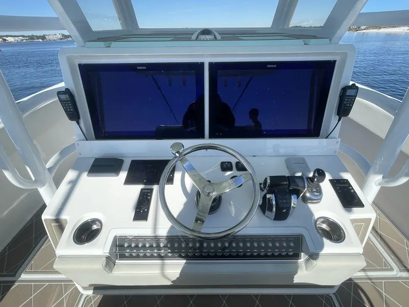 Slide: The Image of 2019 Invincible 40 Catamaran helm view with dual screens and ocean backdrop. - 24