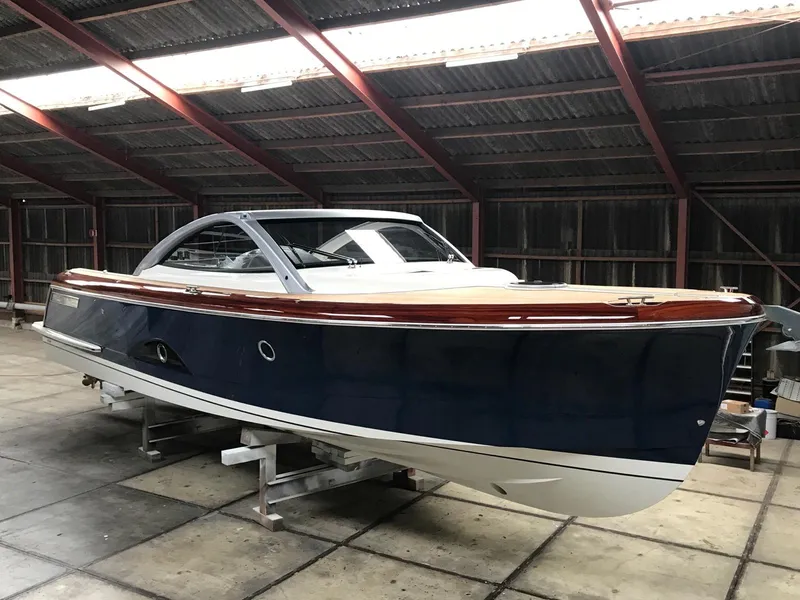 Slide: The Image of 2025 Keizer 42 boat in a warehouse, blue hull, wooden deck, modern design. - 4