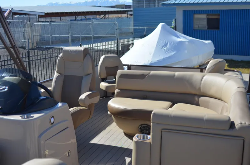 Slide: The Image of 2022 Veranda VF20F4 pontoon boat with beige seating and covered boat in background. - 12