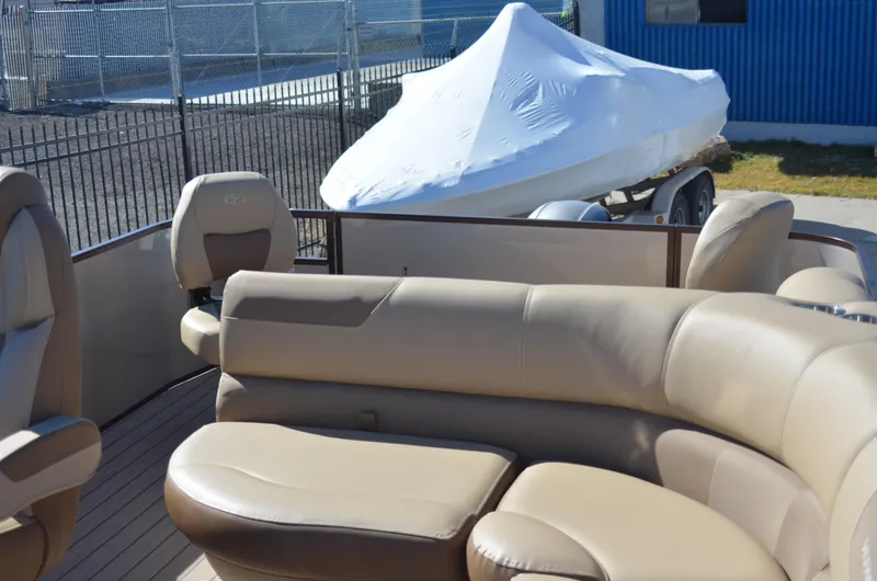 Slide: The Image of 2022 Veranda VF20F4 pontoon boat with beige seating and covered boat in background. - 13