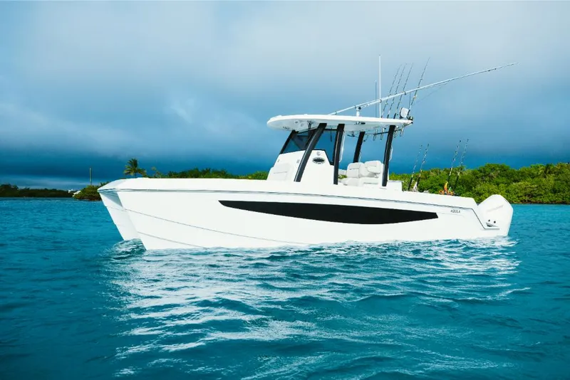 Slide: The Image of 2023 Aquila 28 Molokai boat on blue water with fishing rods. - 1