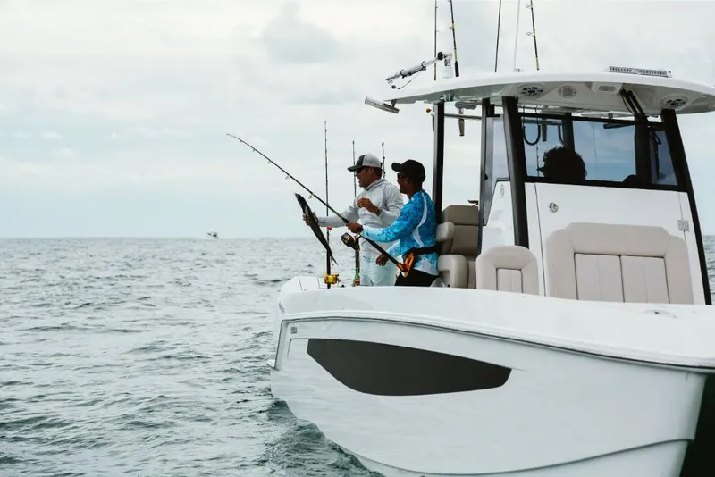 Slide: The Image of 2023 Aquila 28 Molokai boat with two people fishing in open water. - 11