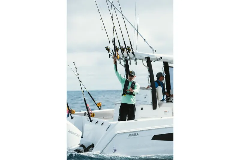 Slide: The Image of 2023 Aquila 28 Molokai boat with anglers holding fishing rods. - 23