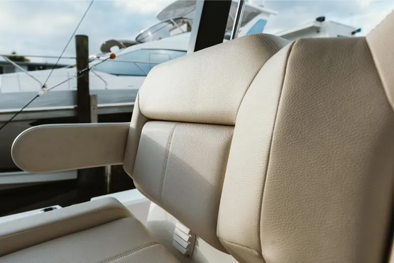 Slide: The Image of Close-up of 2023 Aquila 28 Molokai boat's beige leather seat with armrest. - 29
