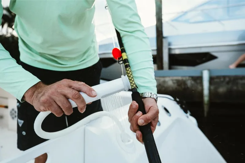 Slide: The Image of Man cleaning fishing rod on 2023 Aquila 28 Molokai boat. - 38