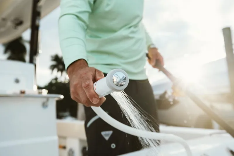 Slide: The Image of Person using a hose on a 2023 Aquila 28 Molokai boat. - 40