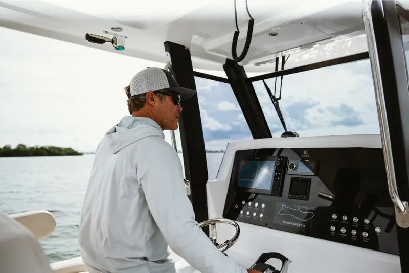 Slide: The Image of Man piloting 2023 Aquila 28 Molokai boat on open water. - 5