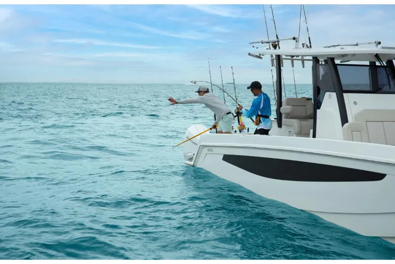 Slide: The Image of 2023 Aquila 28 Molokai boat with people fishing in open water. - 9