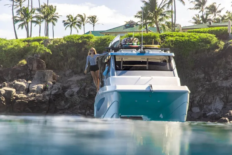 Slide: The Image of 2023 Aquila 28 Molokai Cuddy boat docked near a tropical shoreline. - 10
