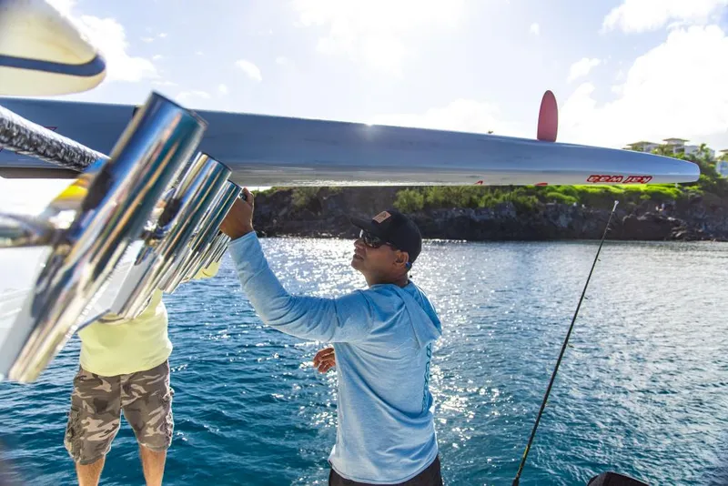 Slide: The Image of Two men on a 2023 Aquila 28 Molokai Cuddy boat, preparing fishing gear. - 14