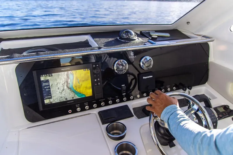 Slide: The Image of 2023 Aquila 28 Molokai Cuddy dashboard with navigation system and steering wheel. - 19