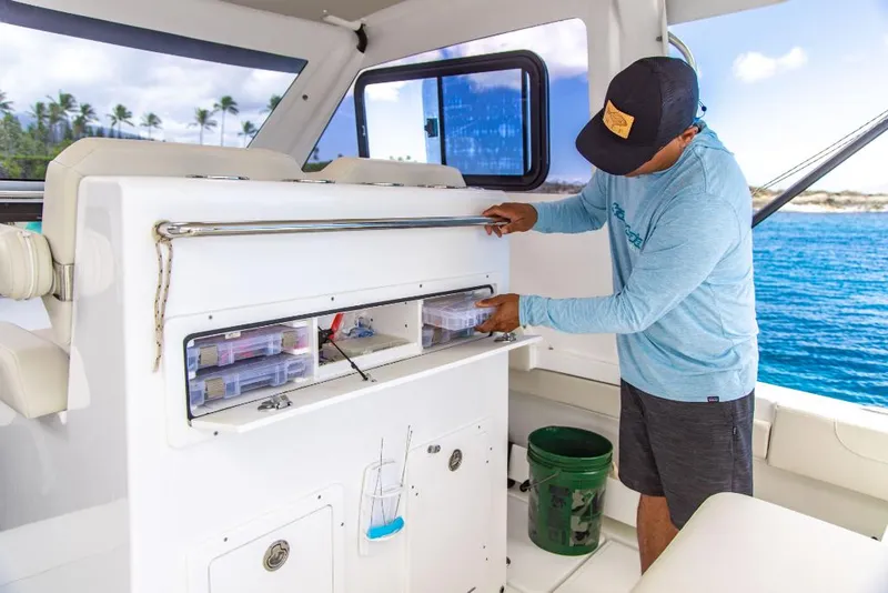 Slide: The Image of Man organizing storage on 2023 Aquila 28 Molokai Cuddy boat. - 24