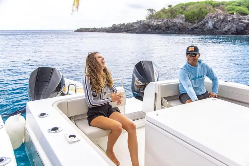 Slide: The Image of 2023 Aquila 28 Molokai Cuddy boat with two people enjoying the ocean view. - 34