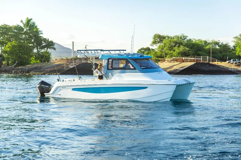 Slide: The Image of 2023 Aquila 28 Molokai Cuddy boat on water near shore. - 4