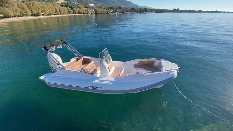 Slide: The Image of 2022 Zar Formenti 59 SL boat on calm water with scenic forest backdrop. - 9