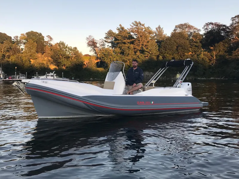 Slide: The Image of 2022 Zar Formenti 59 SL boat on calm water with scenic forest backdrop. - 11