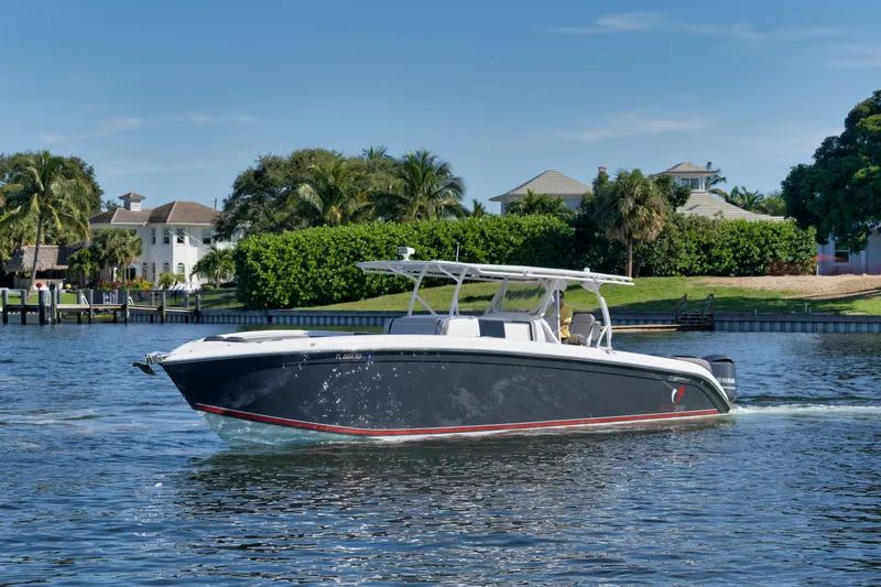 Slide: The Image of 2016 Powerplay Powerboats 42 cruising on a sunny day near waterfront homes. - 13