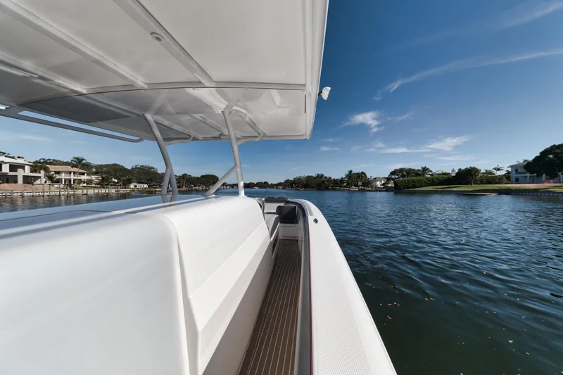 Slide: The Image of 2016 Powerplay Powerboats 42 cruising on a serene waterway under a clear blue sky. - 23