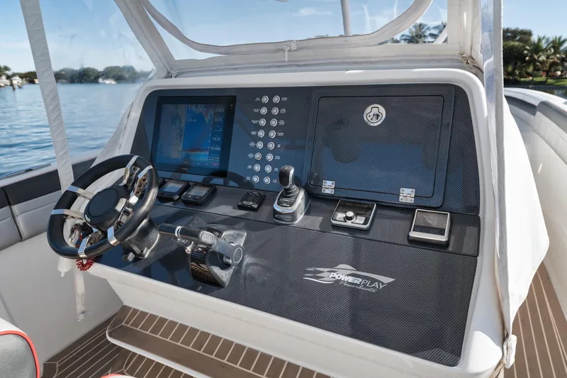Slide: The Image of 2016 Powerplay Powerboats 42 dashboard with steering wheel, control panel, and navigation screen. - 37