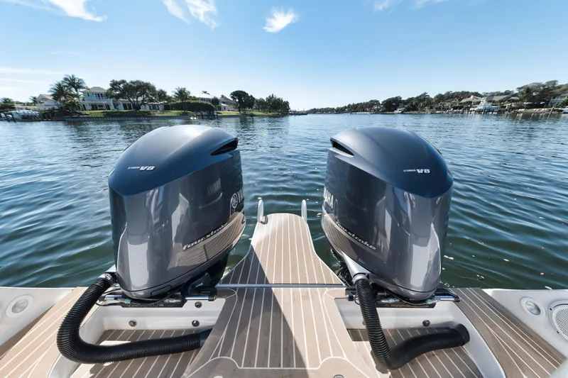 Slide: The Image of Twin outboard motors on a 2016 Powerplay Powerboats 42, cruising on a serene lake. - 38