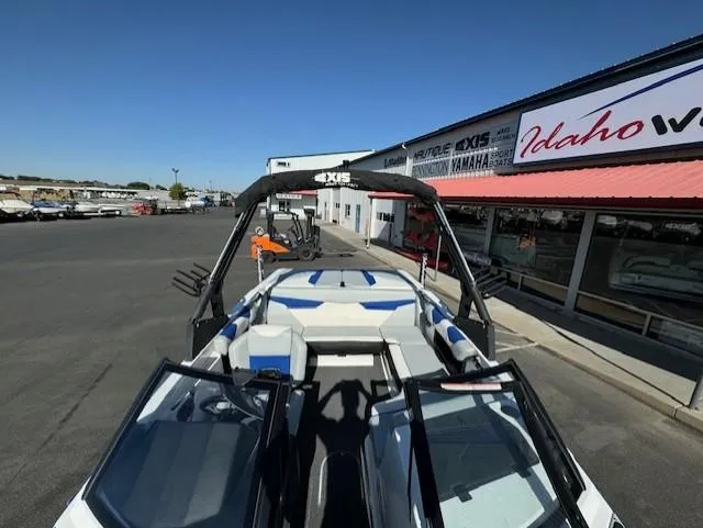 Slide: The Image of 2020 Axis A20 boat with blue and white seating, parked outside a dealership. - 11