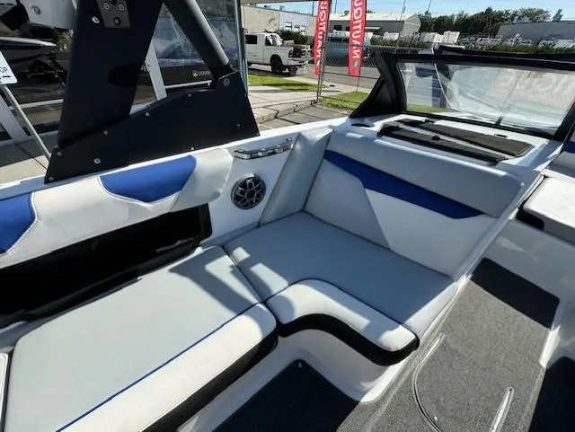Slide: The Image of 2020 Axis A20 boat interior with blue and white seating, speaker, and windshield. - 14