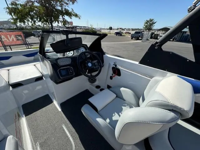 Slide: The Image of 2020 Axis A20 boat interior with steering wheel and seating, parked outdoors. - 15