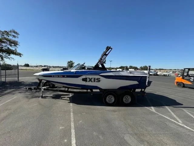Slide: The Image of 2020 Axis A20 boat on trailer in parking lot under clear blue sky. - 7