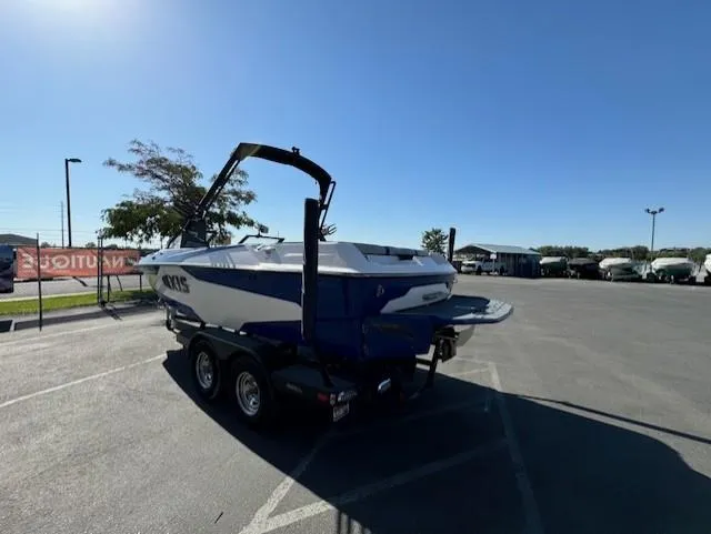 Slide: The Image of 2020 Axis A20 boat on trailer in parking lot under clear blue sky. - 8