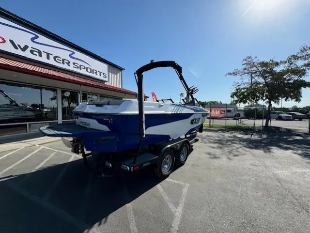 Slide: The Image of 2020 Axis A20 boat on trailer outside water sports store. - 9