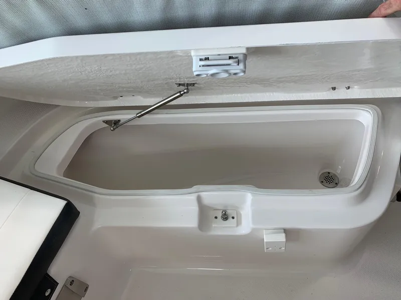 Slide: The Image of 2024 Robalo R202 Explorer storage compartment with open lid. - 9