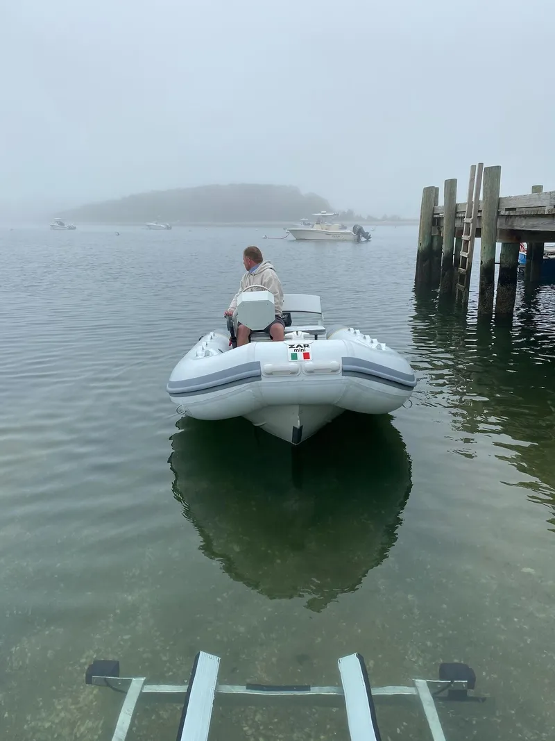 Slide: The Image of 2022 ZAR Mini RIB 14 HDL inflatable boat on calm water near a dock. - 13