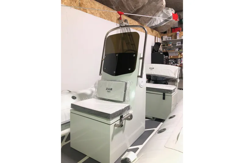 Slide: The Image of 2022 ZAR Mini RIB 14 HDL boat interior with seating and console in a storage area. - 16